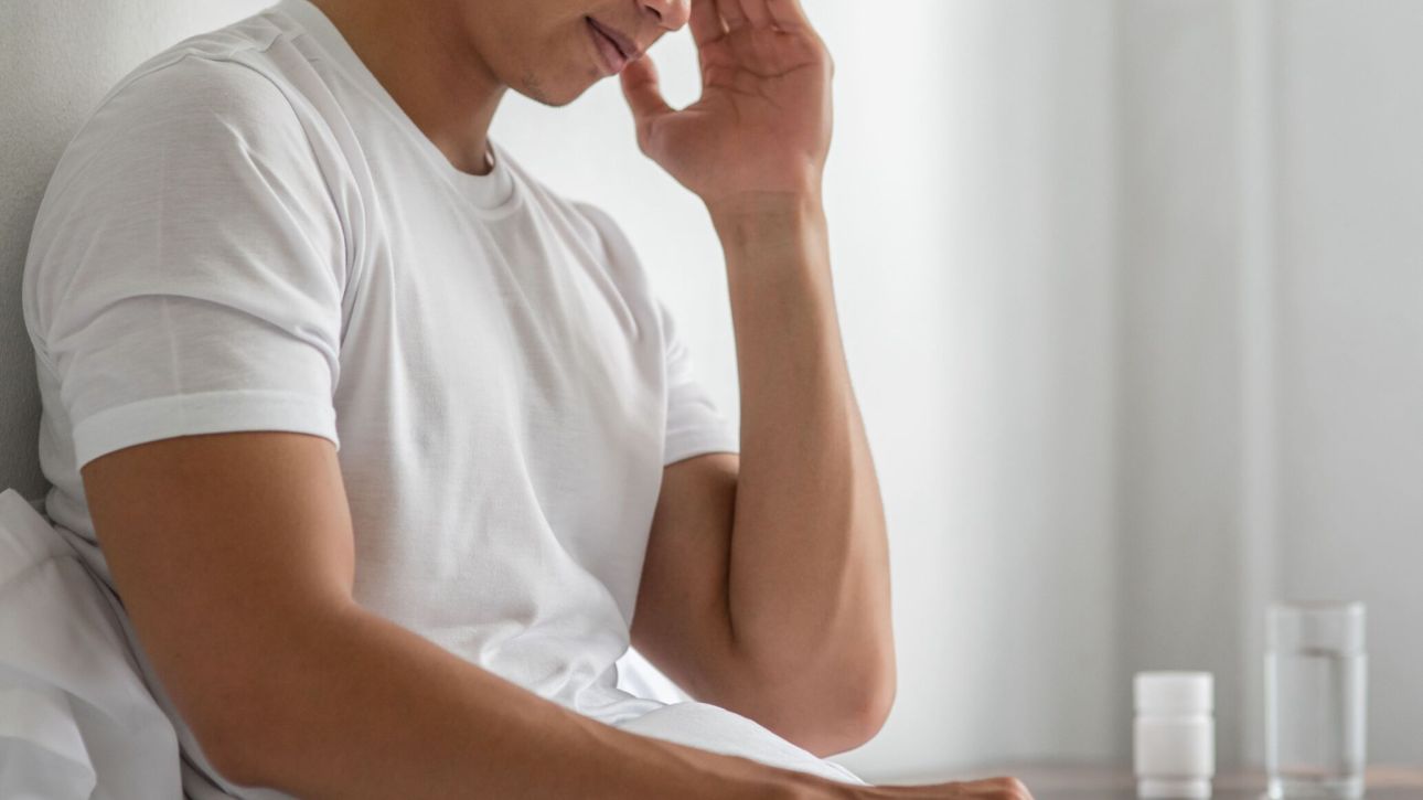 sick-man-sat-bed-touching-her-head-with-his-hand (1)
